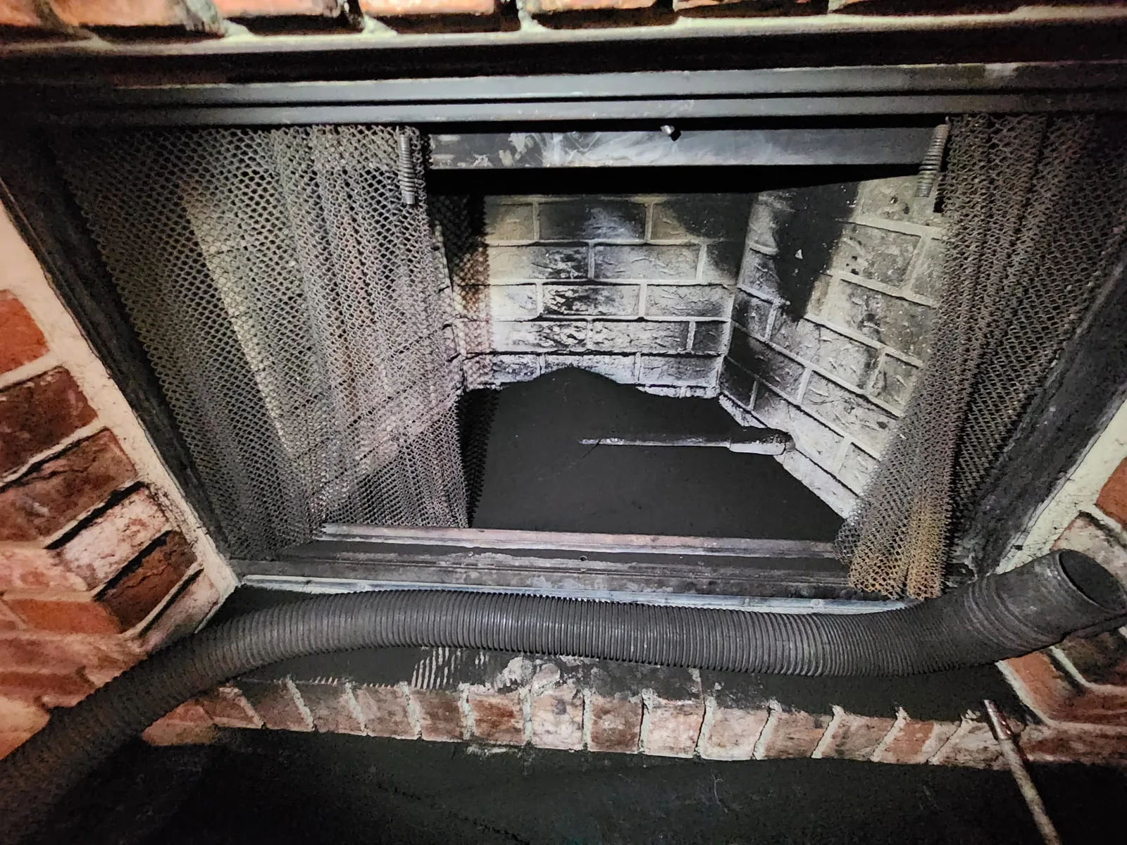 Looking up past a damper into a sooty smoke chamber