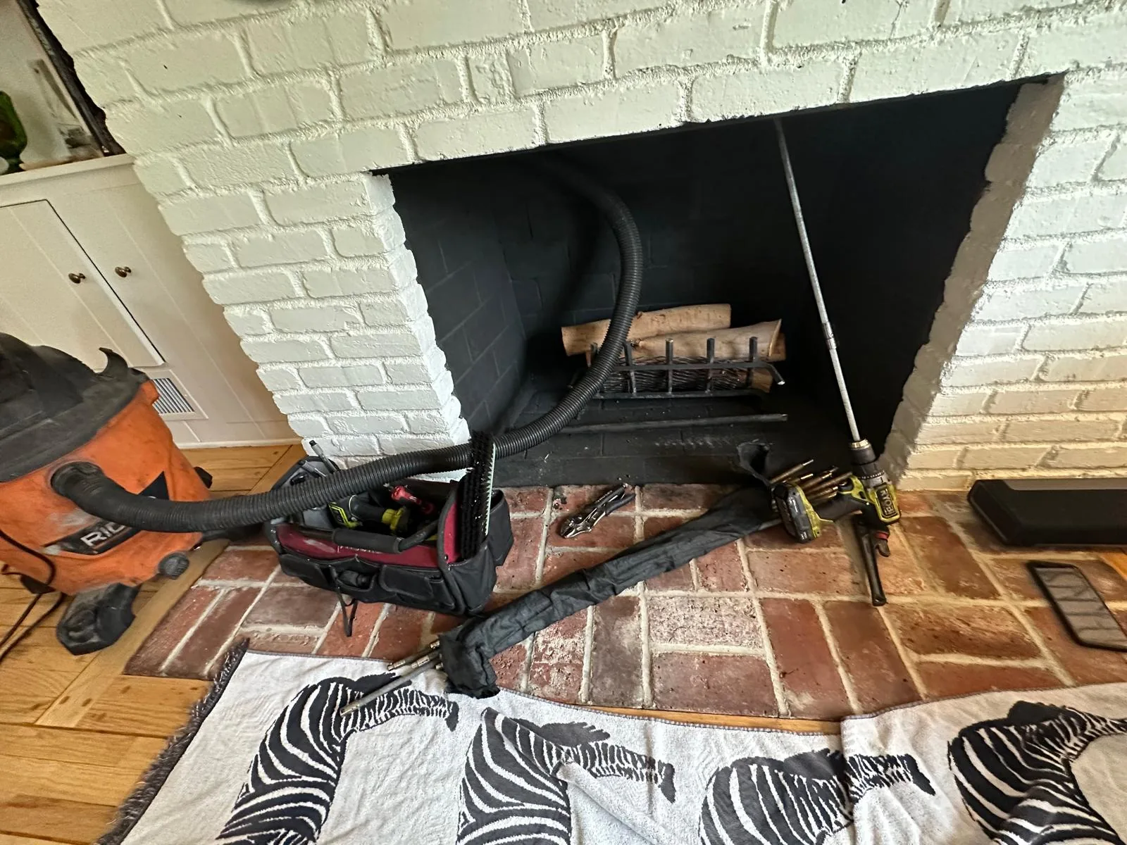 An open firebox with sweeping rods and a HEPA vacuum set up for inspection